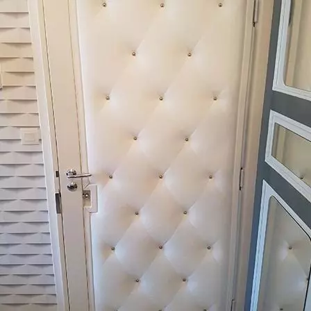 Porte capitonnée crème avec clous dorés